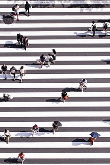 Menschen laufen in verschiedene Richtungen auf einem Zebrastreifen